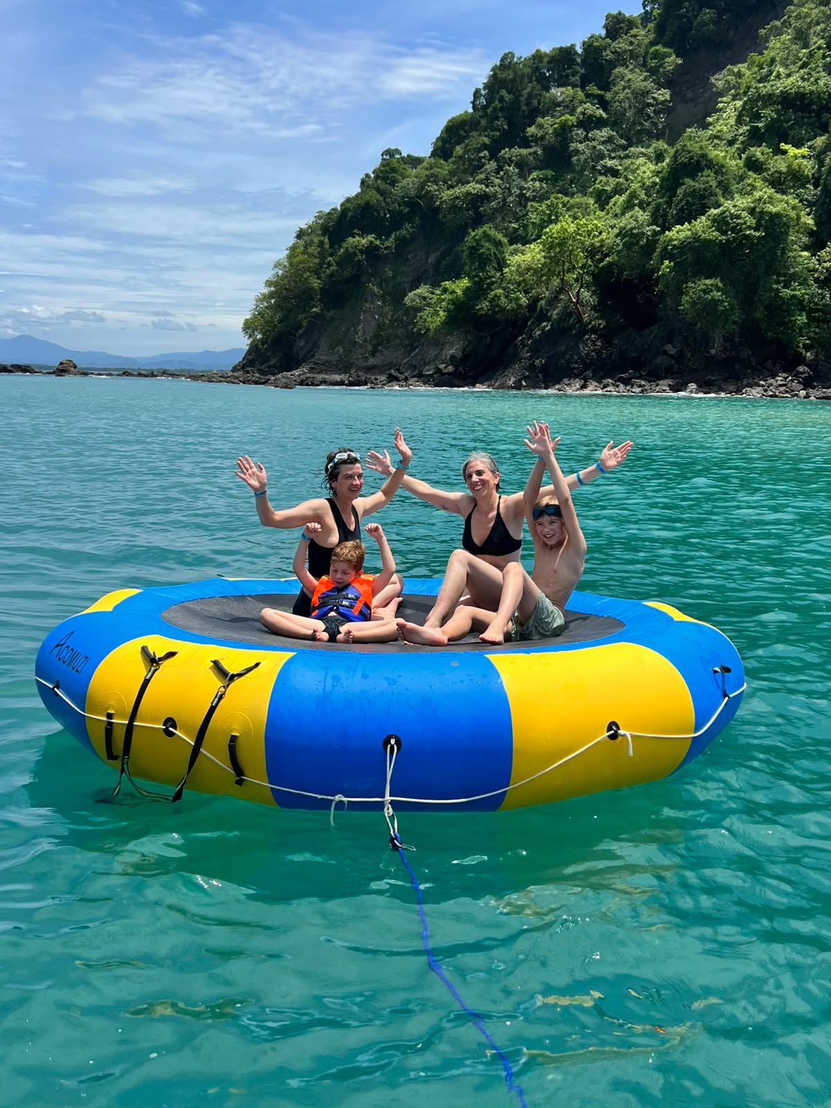 Family waving on water trampoline